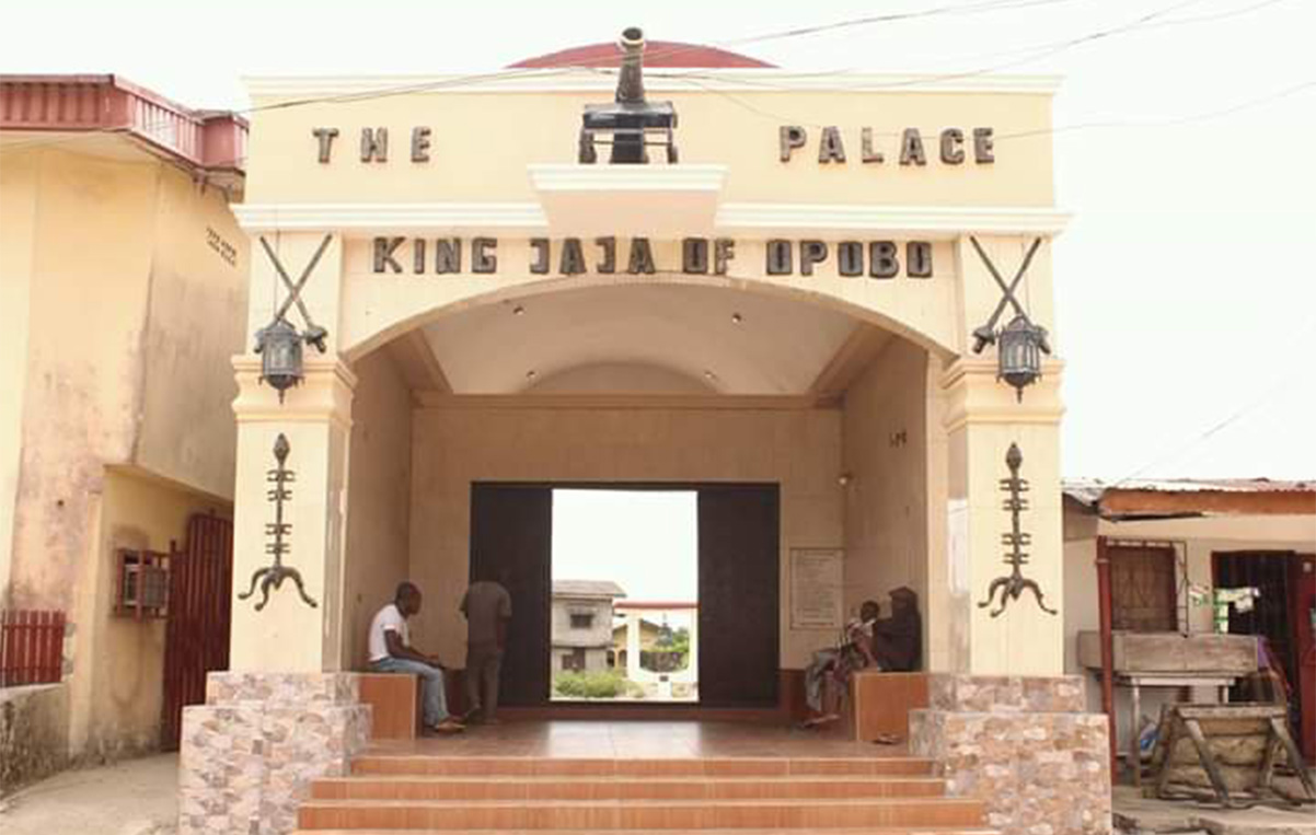 Arched entrance to the Palace of King Jaja of Opobo in Opobo Town, painted with the words 'The Palace, King Jaja of Opobo'