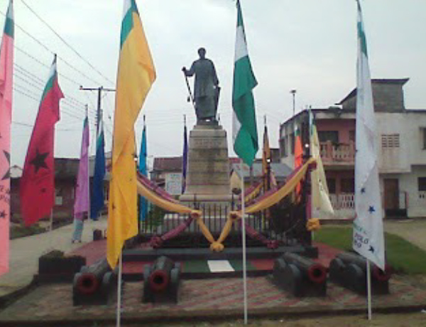 Statue of King Jaja of Opobo adorned with various polo flags